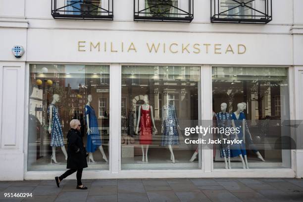 Woman walks past dresses on display in the Emilia Wickstead store on April 26, 2018 in London, England. The designer for Meghan Markle's wedding...