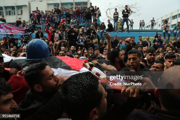 Palestinian mourners carry the body of Palestinian journalist Ahmed Abu Hussein, while who was shot two weeks before by Israeli forces while covering...