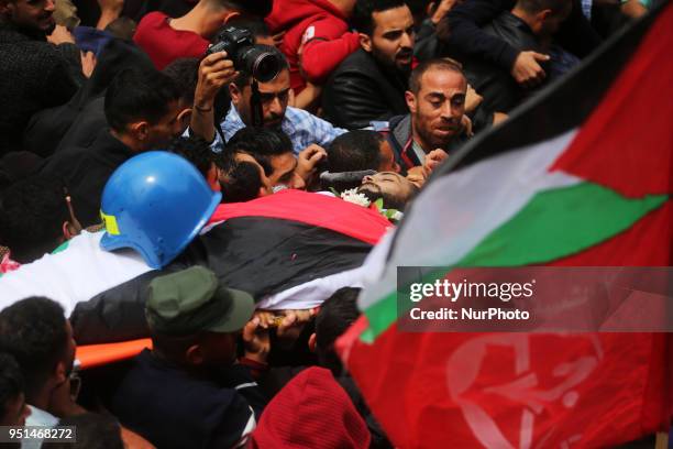 Palestinian mourners carry the body of Palestinian journalist Ahmed Abu Hussein, while who was shot two weeks before by Israeli forces while covering...