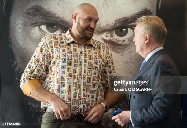 Former British heavyweight world boxing champion Tyson Fury speaks with promoter Frank Warren at a press conference to publicise his return to the...