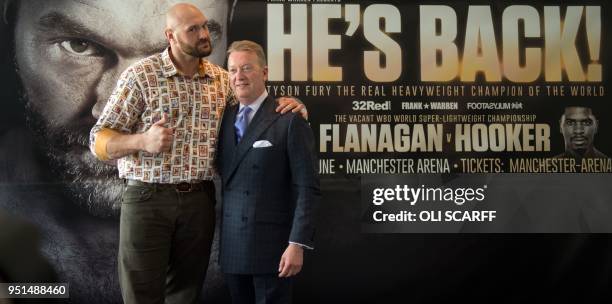 Former British heavyweight world boxing champion Tyson Fury poses for a photograph with promoter Frank Warren at a press conference to publicise his...