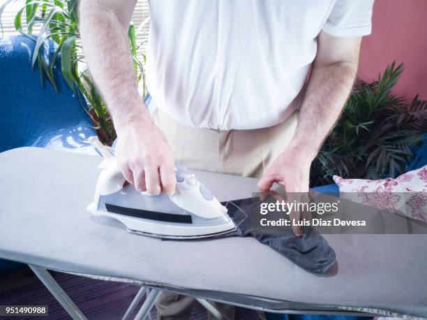 man ironing sock - bügelbrett stock-fotos und bilder