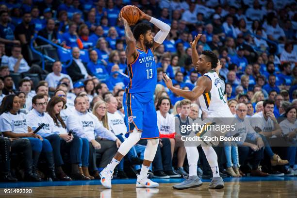 Paul George of the Oklahoma City Thunder looks to pass the ball while guarded by Donovan Mitchell of the Utah Jazz in Game Five during Round One of...