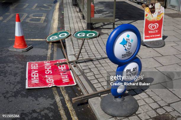 Two GO and Wait traffic road signs lie by the kerb on the ground in East Dulwich, on 26th April 2018, in London, England.