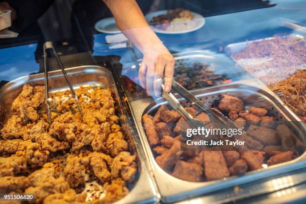 Woman serves herself deep-fried food at an all-you-can eat restaurant in Camberwell on April 26, 2018 in London, England. Party leaders have called...