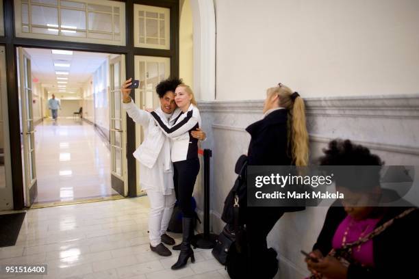 Bill Cosby accusers Lili Bernard and Caroline Heldman pose for a selfie while waiting in line before the courtroom opens at the Montgomery County...