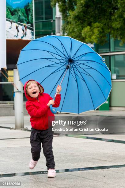 girl running with an opened umbrella at lourdes - hautes pyrénées stock pictures, royalty-free photos & images