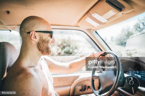 barechested happy young man with sunglasses and beard on a road trip - nudity stock-fotos und bilder