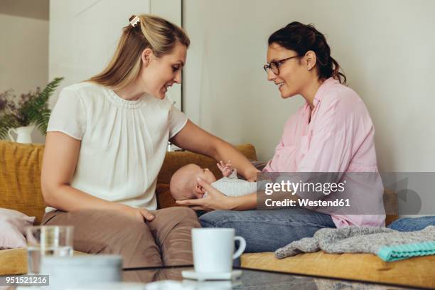 midwife and mother giving newborn baby a belly massage to help with digestion - comadrona fotografías e imágenes de stock