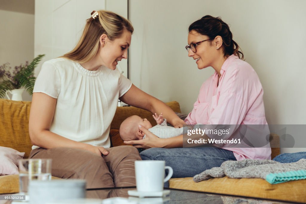 Midwife and mother giving newborn baby a belly massage to help with digestion