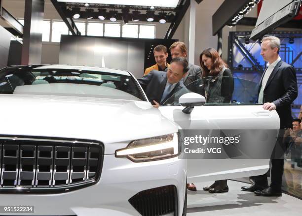 Li Shufu, chairman of Zhejiang Geely Holding Group Co. Sits inside a Polestar 1 electric vehicle during the Auto China 2018 at China International...