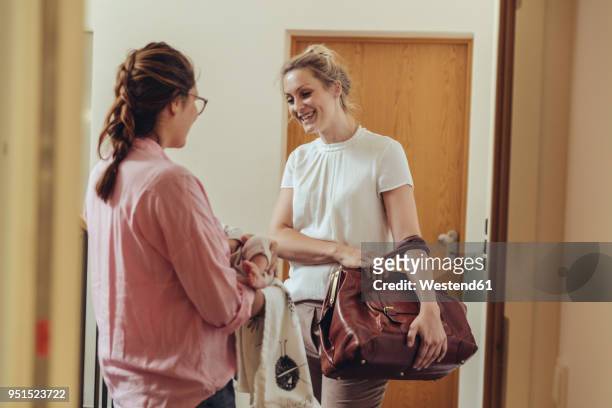 woman greeting midwife at her home’s apartment door - mid wife stock pictures, royalty-free photos & images