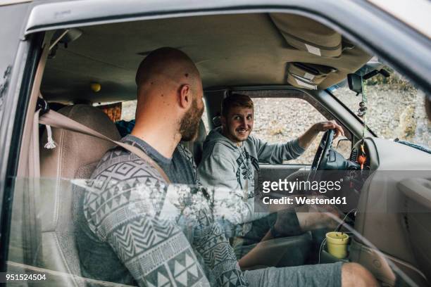 two smiling young men in car on a road trip - two cars ストックフォトと画像