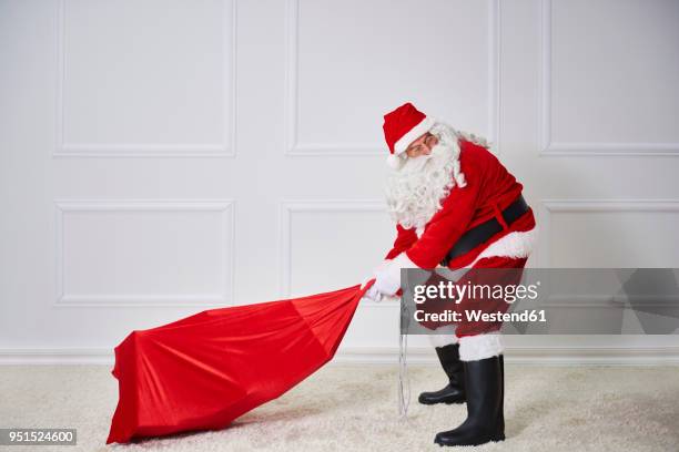 santa claus pulling heavy sack - sack 個照片及圖片檔