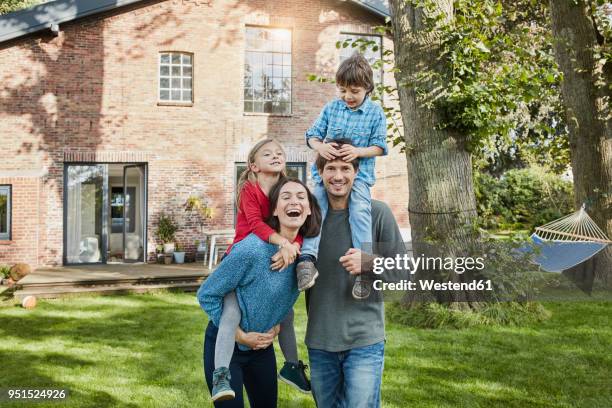 portrait of happy family in garden of their home - stéréotype de la classe moyenne photos et images de collection