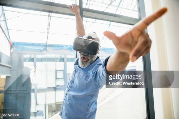businessman wearing vr glasses at the window - new discovery stock pictures, royalty-free photos & images