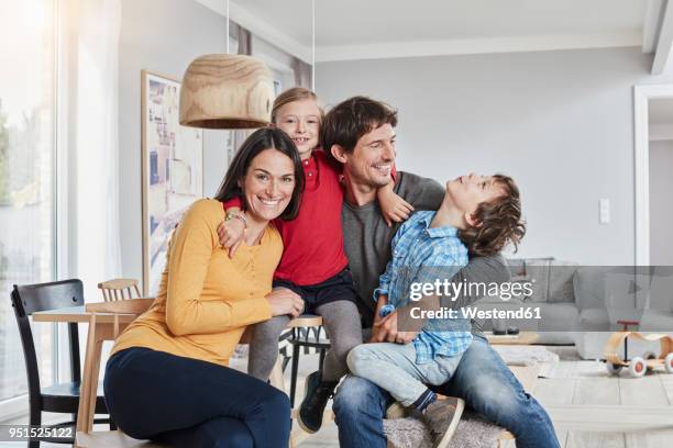 portrait of happy family with two kids at home - kind im grundschulalter stock-fotos und bilder