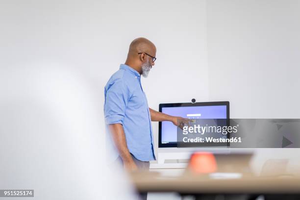 businessman pointing on computer screen - person surrounded by computer screens stock pictures, royalty-free photos & images