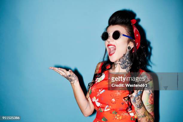 portrait of tattooed woman against blue background - pin up girl tattoo stock pictures, royalty-free photos & images