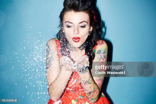 portrait of tattooed woman blowing artificial snow - fake snow stock pictures, royalty-free photos & images