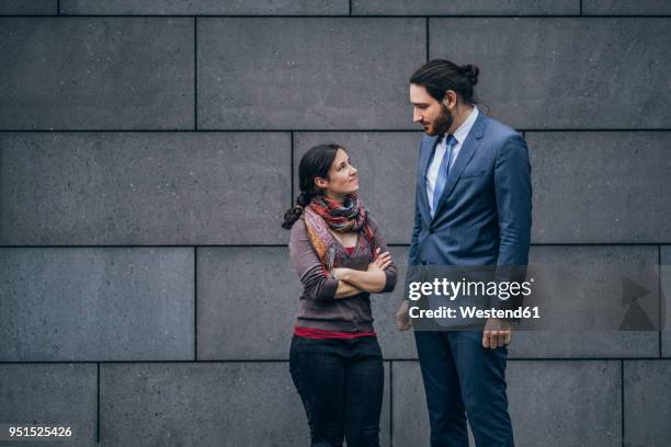 businessman and woman looking at each other - tall stockfoto's en -beelden