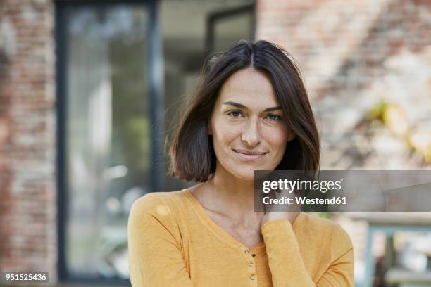 portrait of confident woman in front of her home - 35 39 jahre stock-fotos und bilder