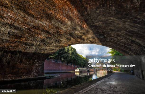 under a bridge on the birmingham canal old line - estrecho descripción física fotografías e imágenes de stock