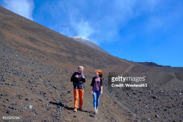 italy, sicily, mount etna, father and daughter hiking - etna stock-fotos und bilder