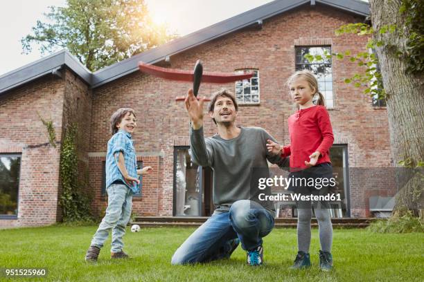 father with two children playing with toy airplane in garden of their home - man builds his own plane imagens e fotografias de stock