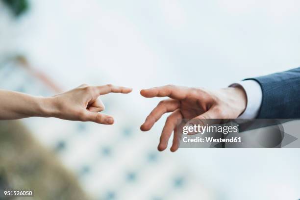 hands of man and woman about to touch - hände greifen stock-fotos und bilder