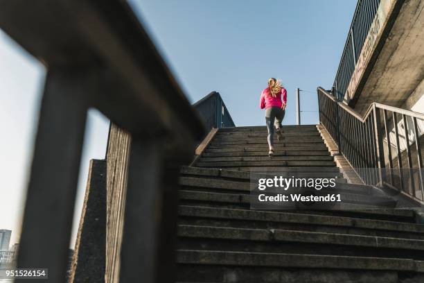 young woman running up stairs - running stock-fotos und bilder