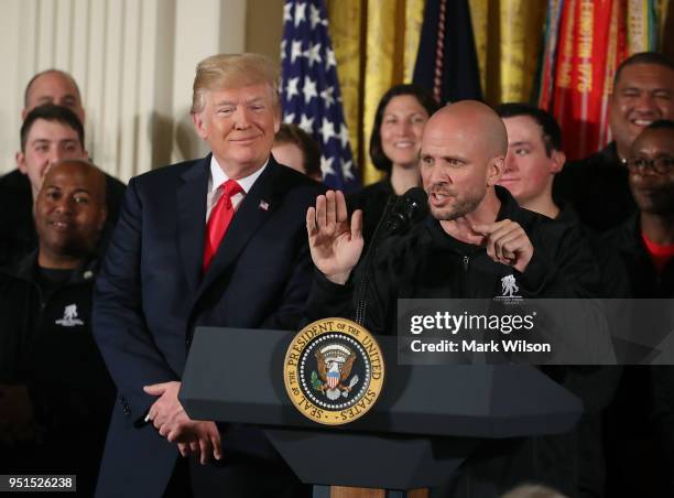 President Donald Trump listens to retired Army Staff Sergeant Dan Nevins speak during an event in the East Room of the White House recognizing the...