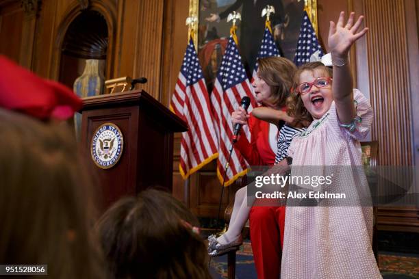 Child waves to her parent as House Minority Leader Nancy Pelosi speaks with journalists' kids during her weekly press conference on 'Take our...