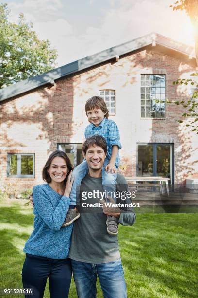 portrait of happy family with son in garden of their home - three people bildbanksfoton och bilder