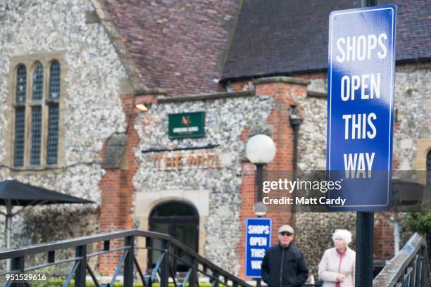 People pass the Mill public house and restaurant as members of the military work in the Maltings shopping area nearby, close to the bench where...