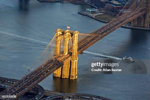 aerial view of light hitting the 'brooklyn bridge' in downtown manhattan - brooklyn bridge stockfoto's en -beelden