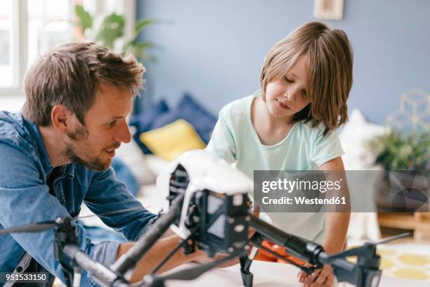 father and son with drone at home - クワッドコプター ストックフォトと画像