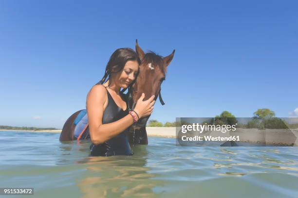 indonesia, bali, woman with horse in the water - bali horse stockfoto's en -beelden