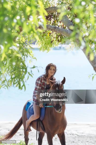 indonesia, bali, woman riding a horse at beach - bali horse fotografías e imágenes de stock