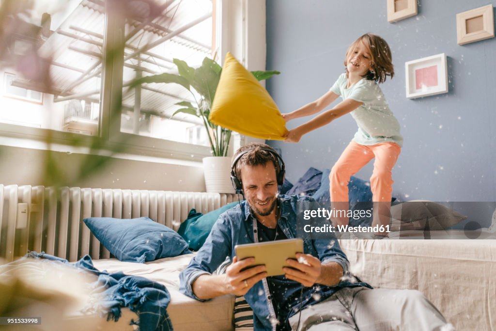 Father and son having a pillow fight at home