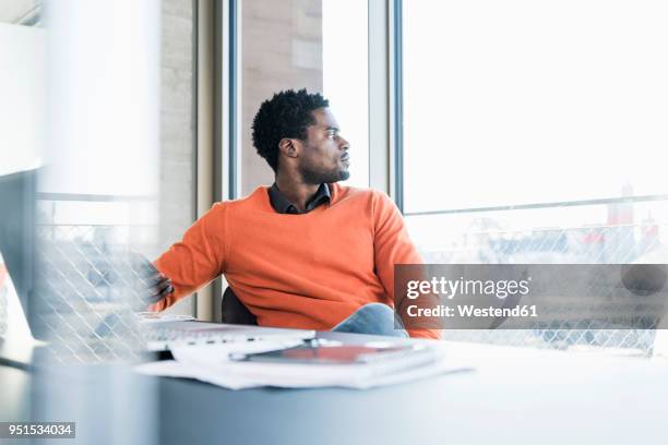 casual businessman sitting at desk looking out of window - office desk top view fotografías e imágenes de stock