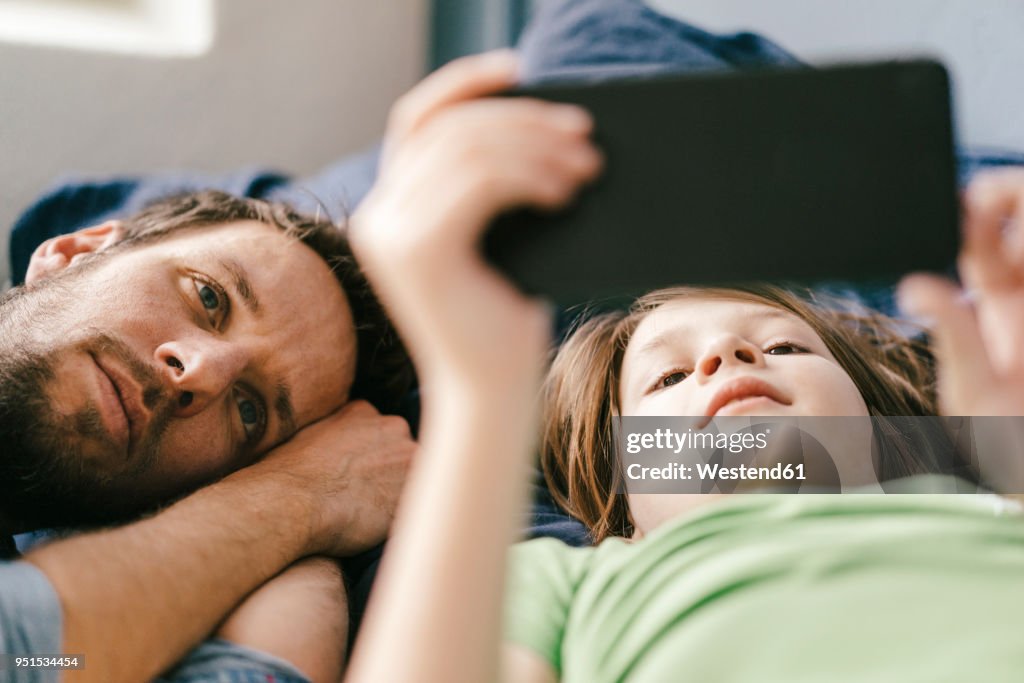 Father and son looking at smartphone together at home