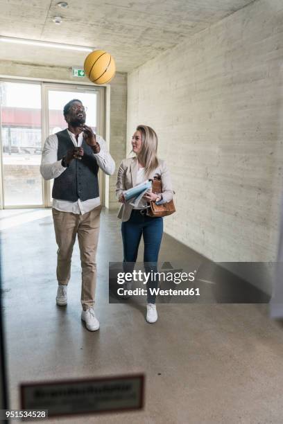 casual businessman with basketball and busineswoman on office floor - german film ball 2018 stock-fotos und bilder