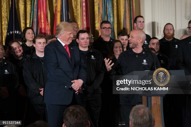 President Donald Trump listens to retired US Army Staff Sargeant Dan Nevins speak at a Wounded Warrior Project Soldier Ride event at the White House...