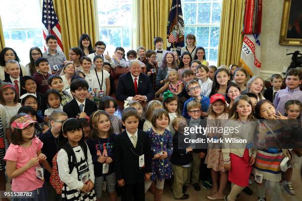 President Donald Trump is surrounded by the children of members of the media and White House staff during Take Your Child To Work Day in the Oval...