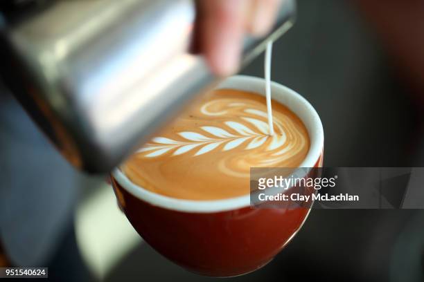 barista pouring milk into cappuccino, oakland, california, usa - coffee art stockfoto's en -beelden