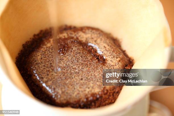 water pouring onto ground coffee in filter, oakland, california, usa - ground coffee stock pictures, royalty-free photos & images