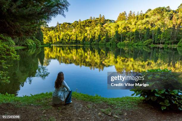 woman sitting in front of lago negro lake in gramado, rio grande do sul, brazil - rio grande do sul stock-fotos und bilder