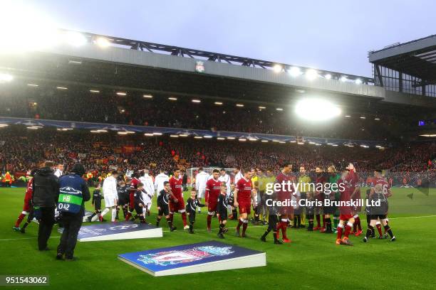 The two teams walk out ahead of the UEFA Champions League Semi Final First Leg match between Liverpool and A.S. Roma at Anfield on April 24, 2018 in...