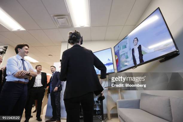 Justin Trudeau, Canada's prime minister, left, watches a demonstration of a virtual reality program during a tour of the Bayview Yards innovation...